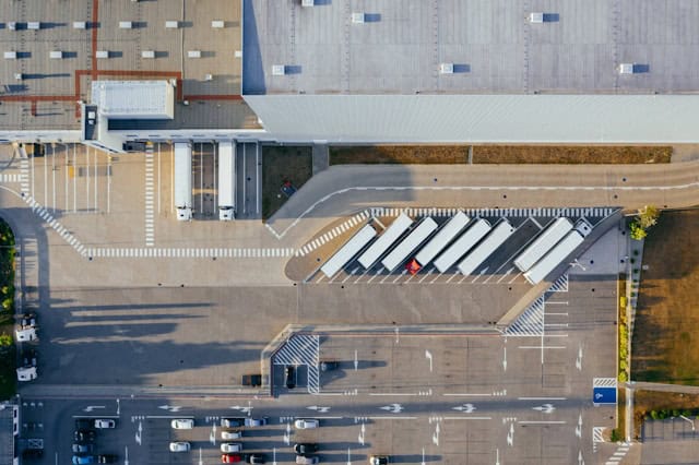 Auf dem Bild ist ein großer Parkplatz mit LKWs aus der Vogelperspektive zu sehen